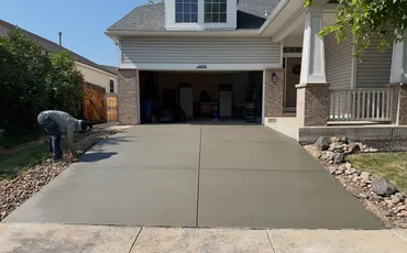 Crew finishing a new two-car concrete driveway