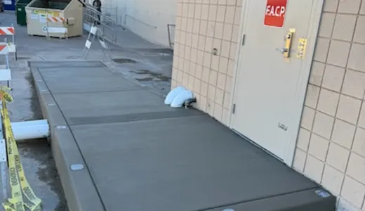 Raised concrete landing foundation at a commercial entry