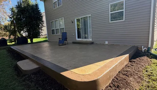 Raised concrete patio deck behind a two-story house