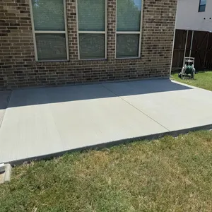 Wide concrete patio next to a brick home